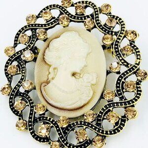 CREAM CAMEO BROOCH WITH BROWN CRYSTAL GLASS RHINESTONES.